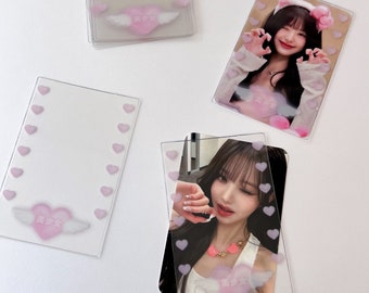 May include: Four clear plastic photo card holders with pink hearts and a pink heart with wings design. The photo cards feature a young woman with long black hair.