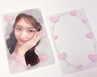 May include: Two clear plastic photo cards with pink hearts around the edges. One card has a photo of a woman with brown hair, and the other card is blank.