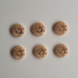 Può includere: Sei bottoni in legno con un design a razzo. I bottoni sono di colore marrone chiaro con venature del legno naturali.