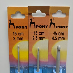 May include: Three Pony brand crochet hooks on their packaging. The hooks are gray and are 15 cm long. The hooks are 2 mm, 2.5 mm, and 4.5 mm in size.