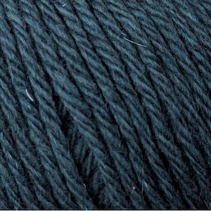 May include: Close-up of dark teal yarn, showing the texture of the fibers. The yarn appears soft and slightly fuzzy, with subtle variations in color. Ideal for knitting or crocheting projects.