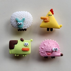 Op de afbeelding: Vier kleurrijke dierenfiguren van plastic. Een wit schaap, een gele kip, een groene koe en een roze egel.