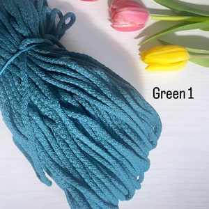 May include: A teal blue cotton rope cord, coiled and ready for crafting projects. The rope is on a white surface with three tulips in the background.