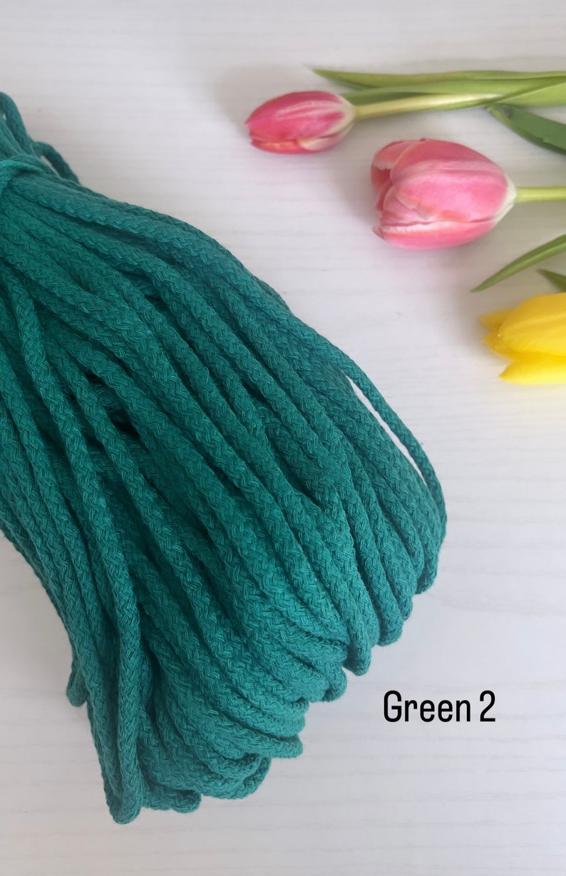 May include: A close-up of a deep green cotton cord, also known as macrame cord,  with the text "Green 2" visible in the image.