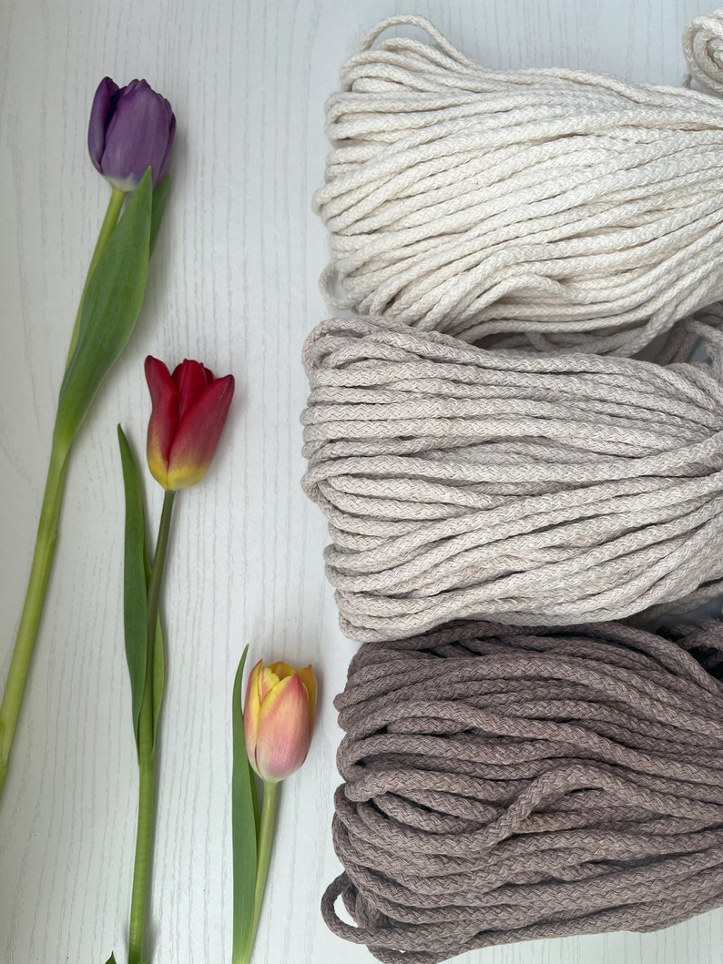 May include: Three spools of natural cotton rope in different colors: beige, light brown, and dark brown. The rope is thick and textured, perfect for crafting.