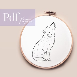Könnte beinhalten: Eine schwarz-weiße Strichzeichnung eines heulenden Wolfs mit Mond und Sternen, dargestellt in einem hölzernen Stickrahmen. Der Text "Pdf Pattern" befindet sich in der oberen linken Ecke.