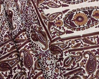 May include: A white fabric with a brown and burgundy paisley pattern. The fabric is folded in half and the pattern is visible on both sides.