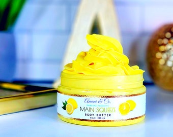 Könnte beinhalten: Ein gelbes Glas mit zitronen-duftendem Körperbutter, beschriftet mit "Amoni & Co. Skincare Products Main Squeeze Body Butter 8 oz | 236 ml."