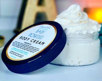 May include: A blue jar with a black lid containing a white body cream. The lid has a white label with the text "A & Co. Skincare Products Baby Powder Body Cream" and a list of ingredients.