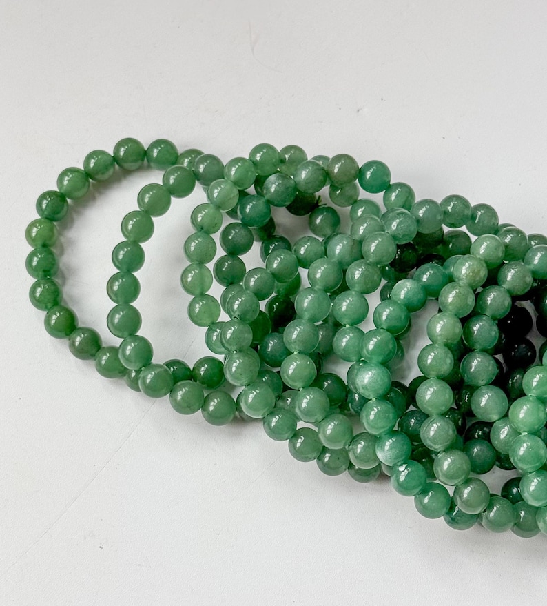 Puede incluir: Varias hebras de cuentas de piedras preciosas verdes. Las cuentas son redondas y tienen un acabado pulido y brillante. El color es un verde medio intenso. Las cuentas est&aacute;n ensartadas, formando collares o pulseras.