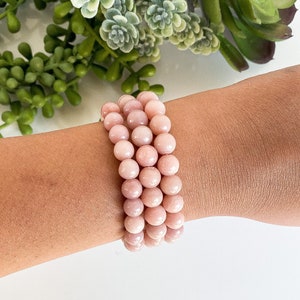 May include: A pink opal beaded bracelet with multiple strands of round beads.