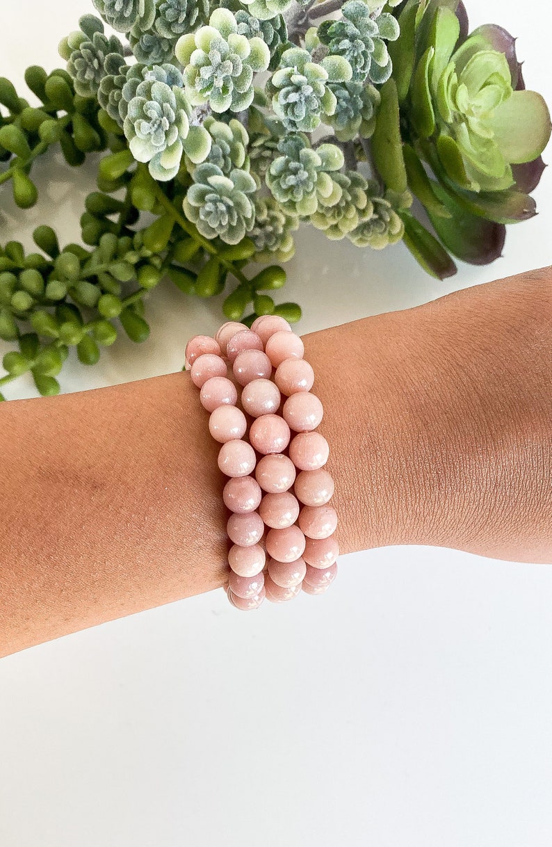 May include: A pink opal beaded bracelet with multiple strands of round beads.