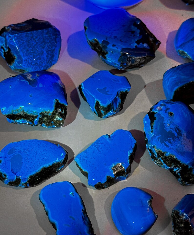 Puede incluir: Una colecci&oacute;n de piedras preciosas azules y negras. Las piedras son lisas y pulidas, con una variedad de formas y tama&ntilde;os.