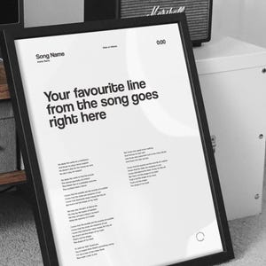 May include: Black framed poster with a white background. The poster features song lyrics and the text "Your favourite line from the song goes right here". The top of the poster has the words "Song Name" and "Date of release".