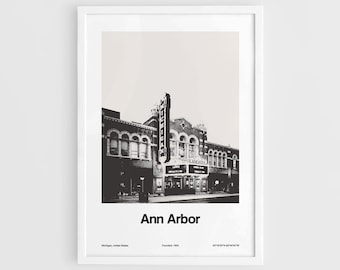 May include: Black and white framed print featuring the Michigan Theater in Ann Arbor. The theater's marquee and facade are visible, with the text "Ann Arbor" below. Includes the founding year and coordinates.