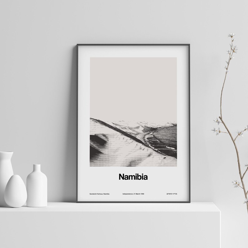 Op de afbeelding: Een zwart-witfoto van een woestijnlandschap met het woord "Namibi&euml;" eronder gedrukt. De tekst "Sandwich Harbour, Namibi&euml;" is linksonder gedrukt, en "Onafhankelijkheid: 21 maart 1990" is onderin het midden gedrukt. De tekst "20&deg;43'S 17&deg;13'E" is rechtsonder gedrukt.