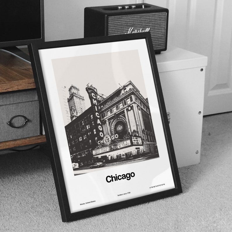 Pu&ograve; includere: Illustrazione in bianco e nero del Chicago Theatre a Chicago, Illinois. L'immagine &egrave; incorniciata in una cornice nera e ha la parola "Chicago" stampata sotto l'illustrazione.