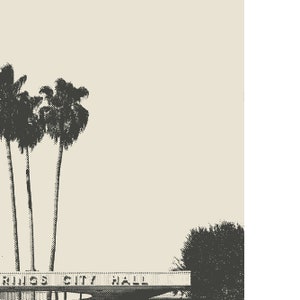 May include: A black and white image of a building with the text "Rings City Hall" above the entrance. There are palm trees in front of the building.