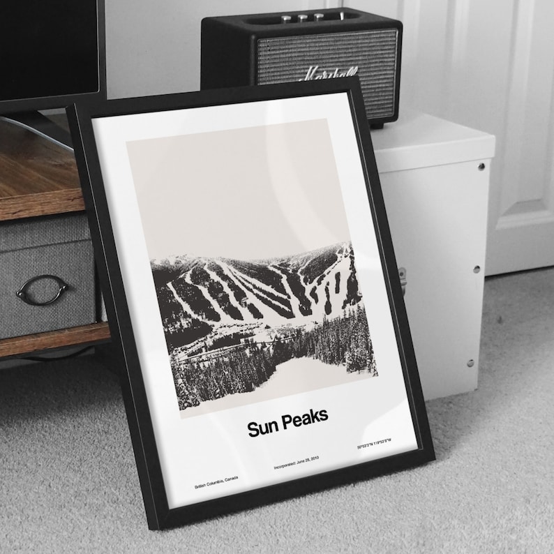 May include: A black and white framed print of a ski resort with the text "Sun Peaks" and "British Columbia, Canada" below the image. The text "Incorporated: June 29, 2003" is in smaller font below the location.