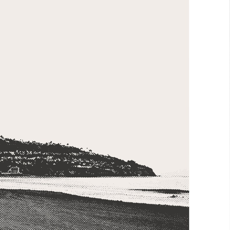 Pode incluir: Uma fotografia a preto e branco de uma praia com uma costa rochosa e um mar calmo.