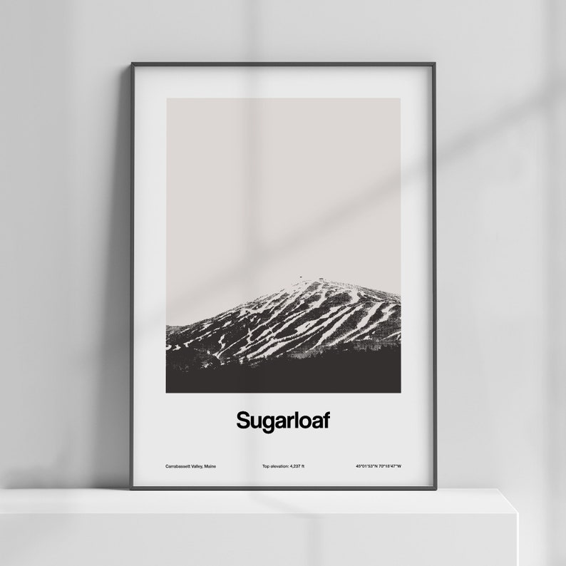 May include: A black and white photograph of Sugarloaf Mountain in Carrabassett Valley, Maine. The mountain is covered in snow and has ski runs visible. The text "Sugarloaf" is printed below the image, along with the mountain's top elevation and coordinates.
