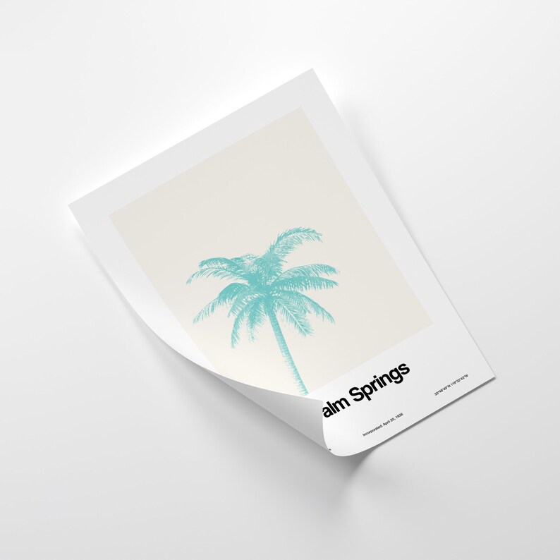 Pu&ograve; includere: Un poster minimalista con una silhouette di palma turchese su uno sfondo crema. Il testo "Palm Springs" &egrave; in basso sul poster, con la data "December 10, 1958" sotto.