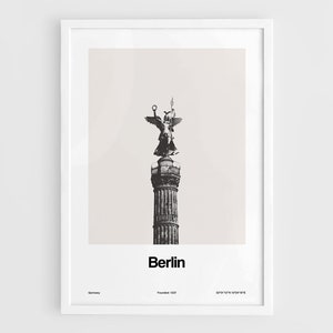 May include: A black and white photograph of the Victory Column in Berlin, Germany. The column is topped with a statue of the goddess Victoria, holding a laurel wreath and a cross. The text "Berlin" is printed below the image, along with the city's founding date, "Founded 1237", and the coordinates "52&deg;31'12"N 13&deg;24'18"E".
