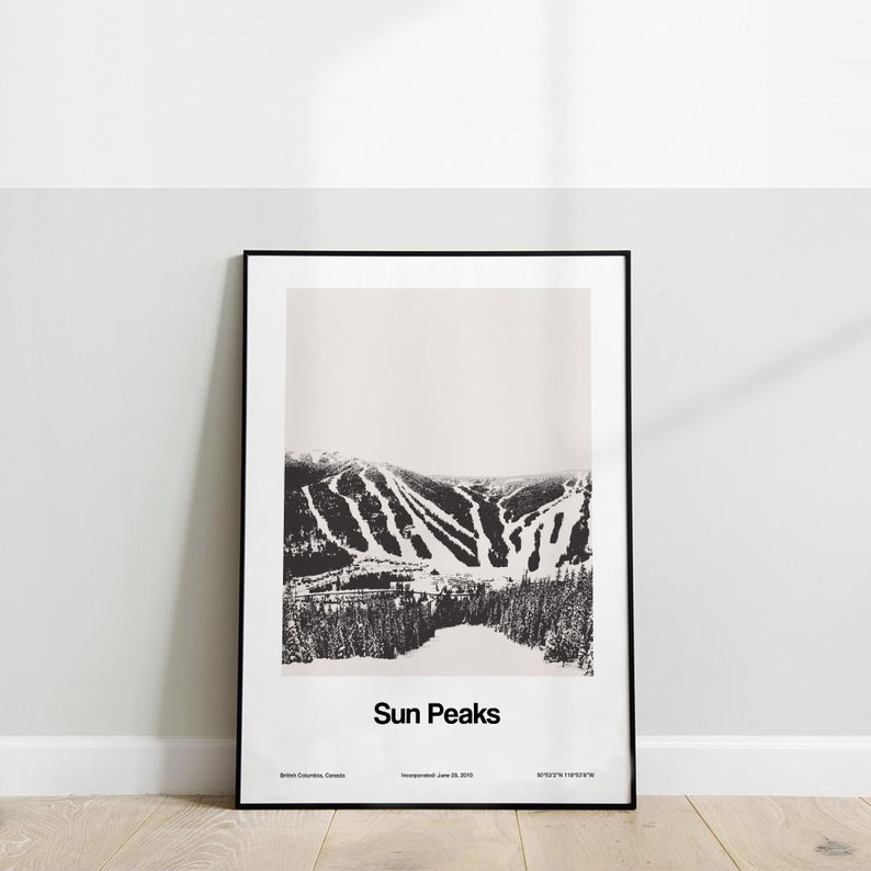 May include: Black and white photograph of a mountain range with ski runs. The image is framed in a black frame and has the text "Sun Peaks" at the bottom. The text "Incorporated June 25, 2010" and "British Columbia, Canada" are also included.