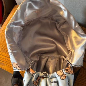 May include: A blue and white fabric bag with a satin lining. The bag has a repeating pattern of golden retriever dogs and the text "Life is Golden".