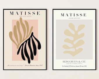 Op de afbeelding: Twee ingelijste Matisse-kunstprints. De linkerprint toont abstracte vormen in zwart, beige en roze, met tekst. De rechterprint heeft een beige bladvorm op een lichtgrijze achtergrond, met tekst. Beide zitten in zwarte lijsten.