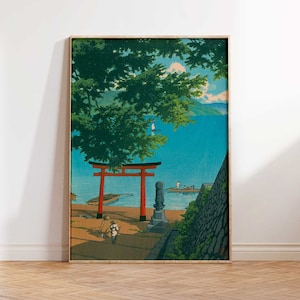 May include: A framed print of a Japanese landscape with a red torii gate, a blue body of water, and a green tree in the foreground. The print is in a wooden frame.