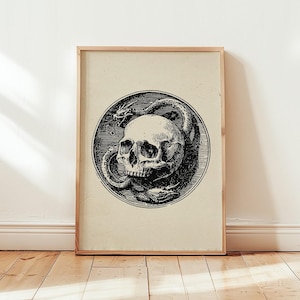 May include: A framed rectangular print featuring a black ink illustration of a human skull encircled by a dragon. The artwork is presented in a circular border with detailed cross-hatching, set against a light beige background within a wooden frame.
