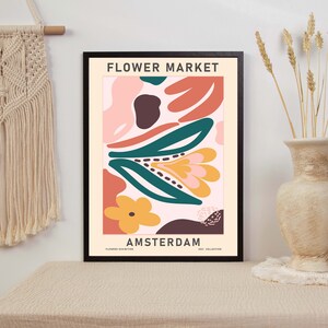 K&ouml;nnte beinhalten: Ein gerahmtes Poster mit einem farbenfrohen abstrakten Blumendesign. Das Poster tr&auml;gt den Text "FLOWER MARKET AMSTERDAM" unten.
