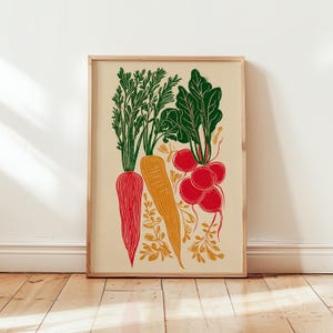 Könnte beinhalten: Ein gerahmter Druck mit einer farbenfrohen Illustration von Wurzelgemüse. Das Kunstwerk zeigt eine rote Karotte, eine orangefarbene Karotte und eine Gruppe roter Radieschen mit grünen Blättern. Der Hintergrund ist hellbeige.