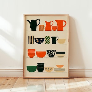 May include: A framed art print featuring four horizontal shelves displaying various ceramic kitchenware. The illustration includes teapots, pitchers, and bowls in shades of orange, dark green, black, and cream, decorated with stripes, checkers, and floral patterns.