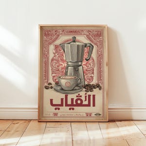 Puede incluir: Un estampado enmarcado de estilo vintage con temática de café. La obra de arte muestra una cafetera italiana plateada, una taza de café sobre un platillo y granos de café. El texto de la imagen está en un idioma extranjero, con una combinación de colores rojo y crema.