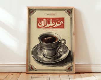 May include: A framed vintage-style print featuring a cup of coffee on a saucer. The cup and saucer are silver with intricate detailing. The print has a beige background with Arabic text in a red rectangle at the top.