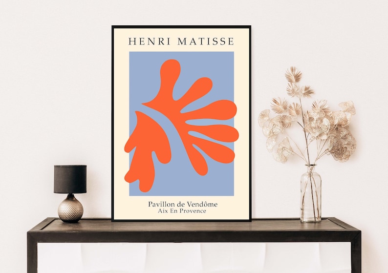 May include: A minimalist poster featuring a red abstract shape on a light blue background. The poster is framed in black and includes the text "HENRI MATISSE", "Pavillon de Vend&ocirc;me", and "Aix En Provence".