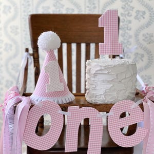 Roze gingham ONE-banner en hoed voor kinderstoel voor een eerste verjaardag
