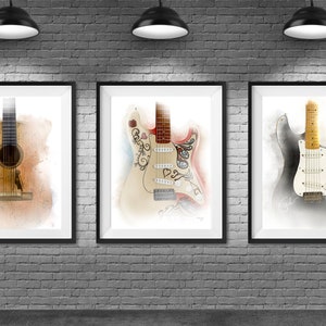 May include: Three framed watercolor prints of guitars hang on a gray brick wall. The prints feature an acoustic guitar, a white electric guitar with decorative elements, and a white electric guitar.