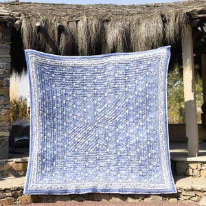 Puede incluir: Una colcha kantha azul y blanca con un patrón floral. La colcha está cosida a mano y tiene un diseño tradicional indio.