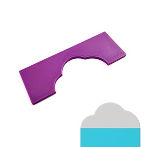 May include: A purple plastic stencil with a scalloped arch shape. The stencil is designed for crafting and decorating.