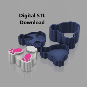 Op de afbeelding: Drie 3D-geprinte koekjesvormen in de vorm van een konijn. De vormen zijn blauw en wit met roze accenten. De tekst "Digitale STL-download" is zichtbaar in de afbeelding.