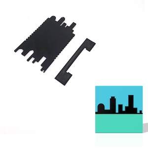 May include: Black plastic pieces for a model building kit. The pieces are shaped like a city skyline with buildings and a dome.