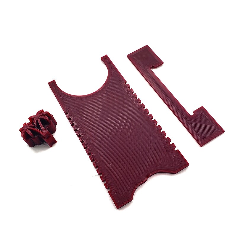 May include: A set of three red plastic tools for scraping and cleaning. The tools are shaped like a comb, a rectangle with a cut-out, and a palm tree.