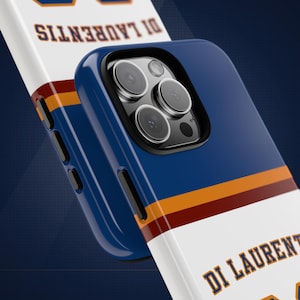 May include: A blue, white, orange, and maroon phone case featuring the text DI LAURENTIS in blue lettering. The case has a cutout for a triple-lens camera system and black side buttons, displaying a sports jersey-inspired design pattern.