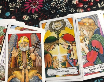 May include: A set of tarot cards featuring colorful illustrations. The cards include "The Hierophant", "Two of Cups", and "Queen of Cups".