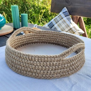 May include: A white ceramic mug with a black handle and the text "But First, Coffee" in a bold, black font. The mug is filled with a dark liquid, likely coffee, and sits on a white surface.