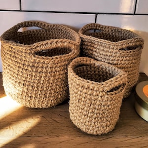 Crocheted round jute baskets with handels. Storage organizaton bathroom and kitchen. Set small wicker baskets. Natural eco-friendly decor.