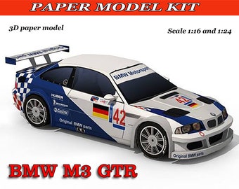 Może przedstawiać: Papierowy model do złożenia białego, niebieskiego i czerwonego samochodu wyścigowego BMW M3 GTR. Samochód ma numer 42 na boku i napis "BMW Motorsport" na przedniej szybie. Zestaw zawiera oryginalne części BMW i jest dostępny w skalach 1:16 i 1:24.